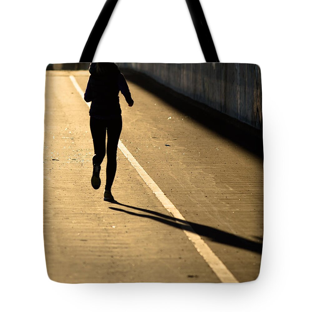 Girl Tote Bag featuring the photograph Female Jogger In Backlight by Andreas Berthold