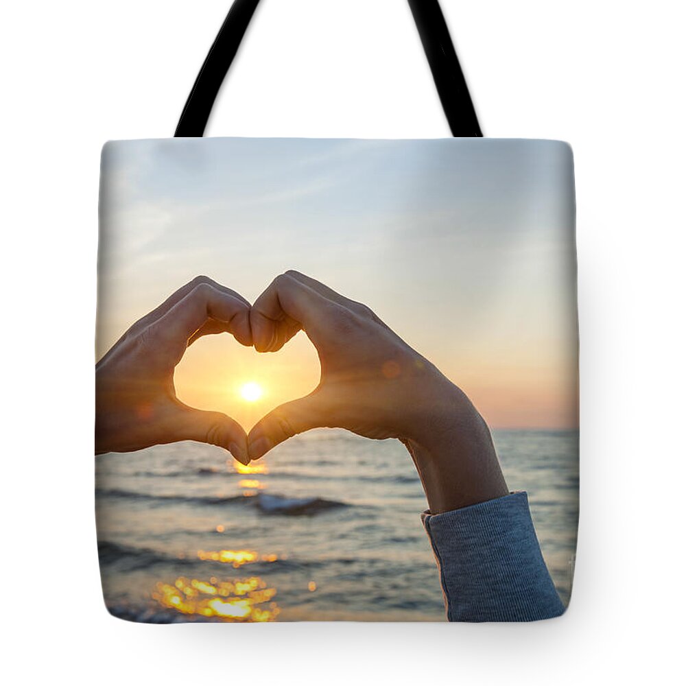 Heart Tote Bag featuring the photograph Fingers heart framing ocean sunset by Elena Elisseeva