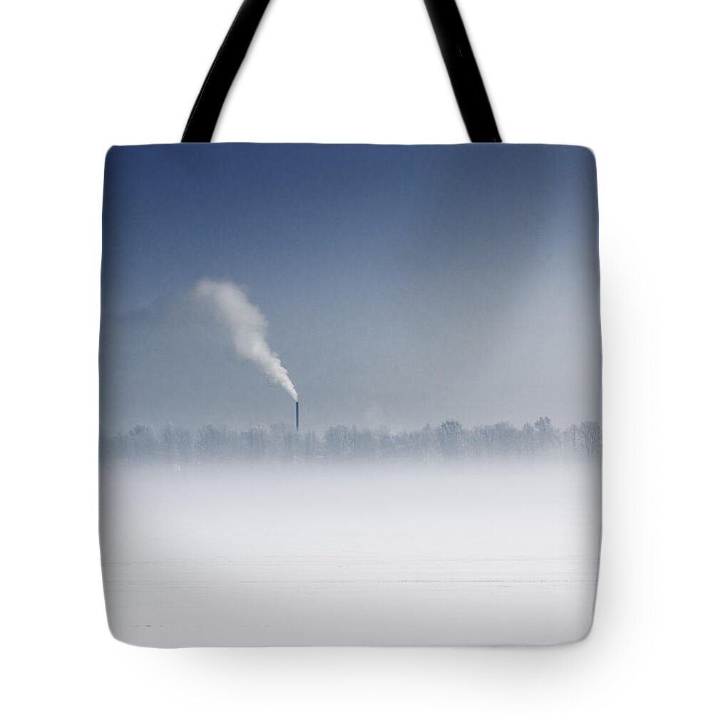 Environmental Damage Tote Bag featuring the photograph Fog Over Frozen River With Fuming Pipe by Dmitry Savin