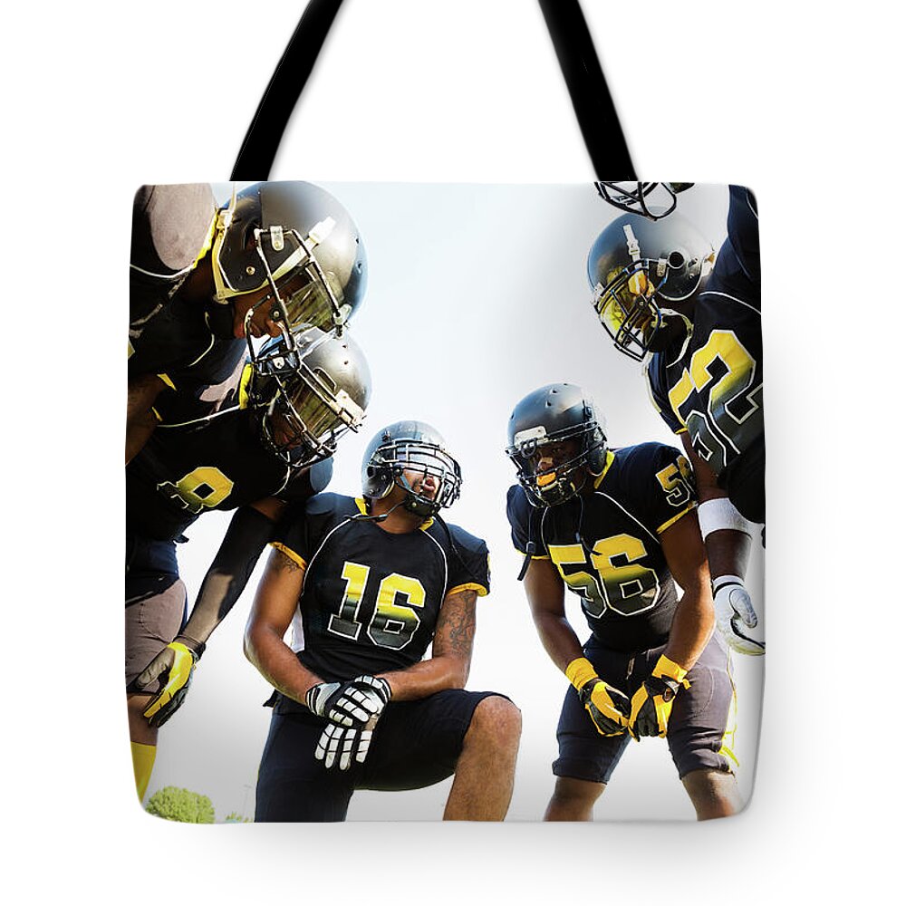 Young Men Tote Bag featuring the photograph Football Team Huddled During Time Out by Asiseeit