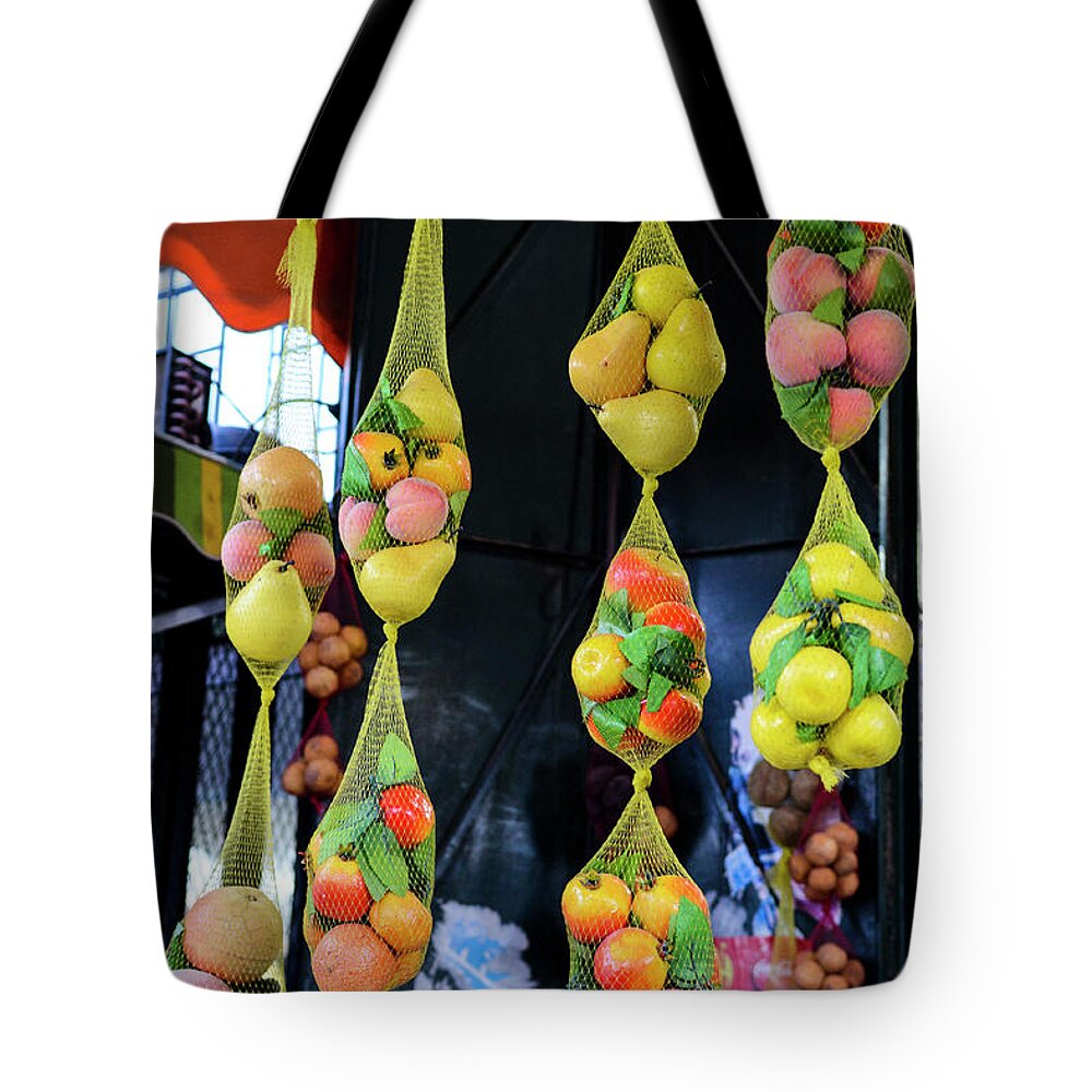 Hanging Tote Bag featuring the photograph Fruits Hanging From A Market Stall by Paolo Negri