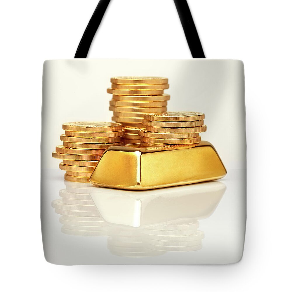 White Background Tote Bag featuring the photograph Gold Ingot In Front Of Gold Coins by Anthony Bradshaw