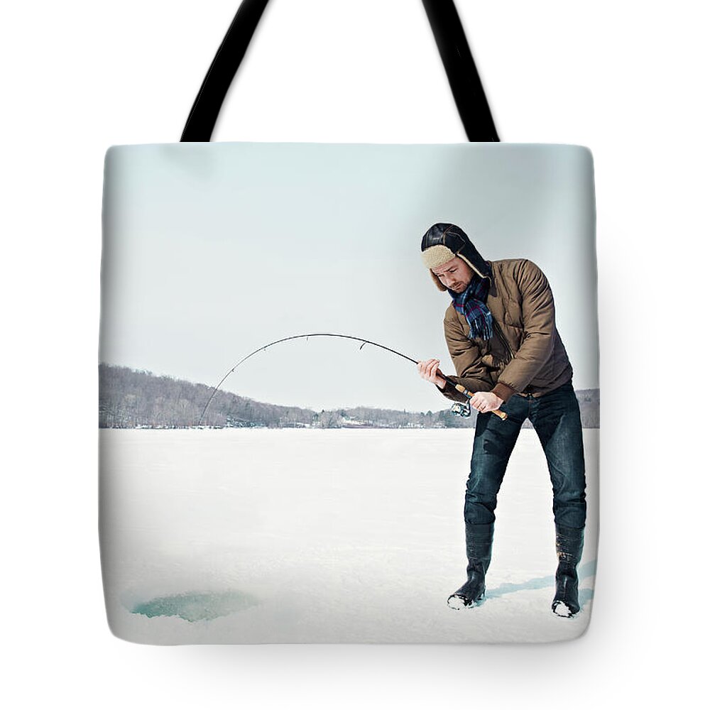 People Tote Bag featuring the photograph Man Ice Fishing On Frozen Lake by Andy Ryan