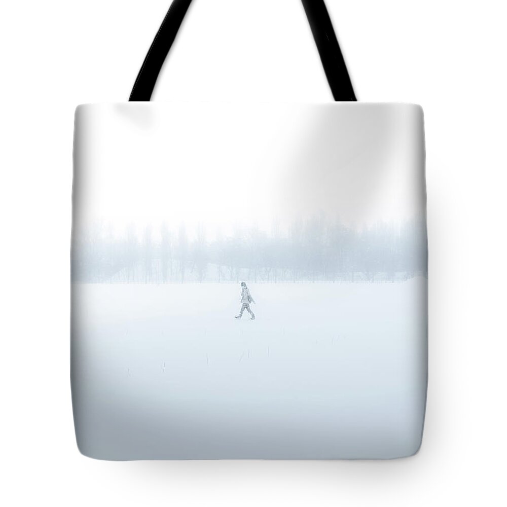Scenics Tote Bag featuring the photograph Man Walking Through A Snowfield by Taketan