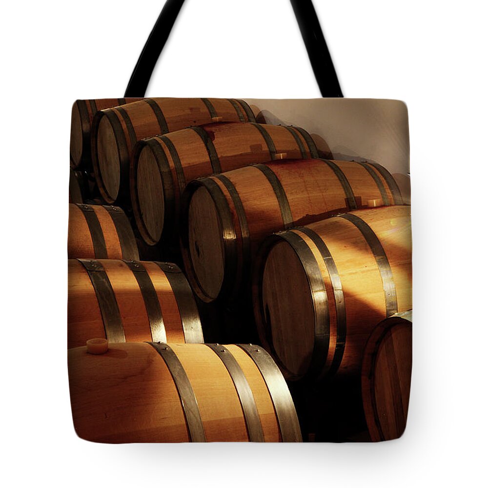 Alcohol Tote Bag featuring the photograph Oak Barrels In A Cellar by Seraficus