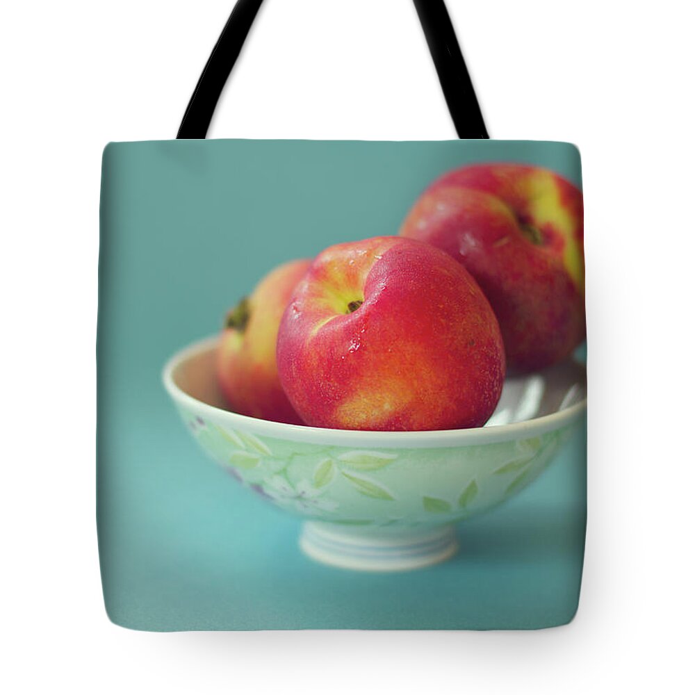 Close-up Tote Bag featuring the photograph Peaches In Bowl On Blue Background by Copyright Anna Nemoy(xaomena)