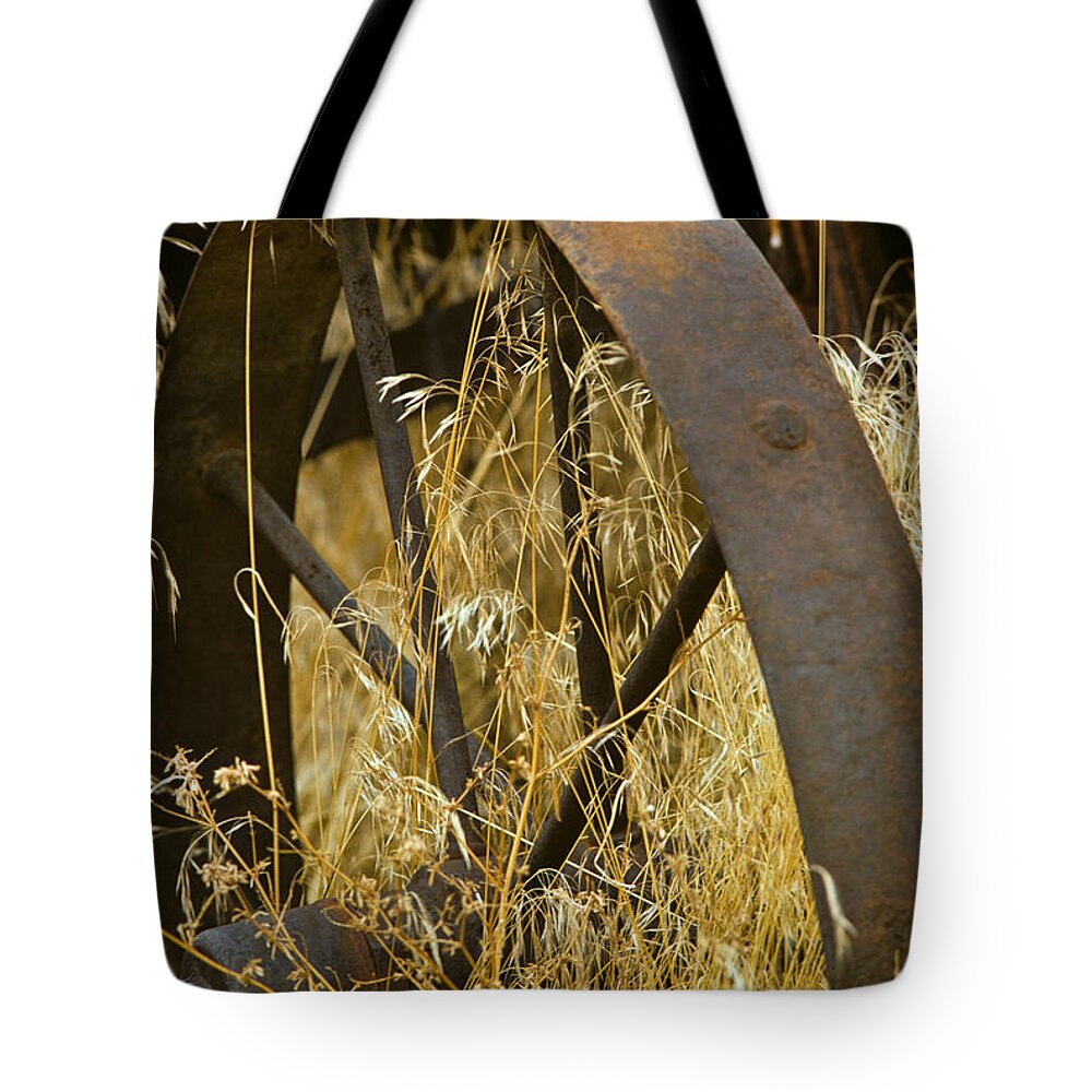 Agricultural Activity Tote Bag featuring the photograph Rusty Old Wheel and Yellow Grasses by Jeff Goulden