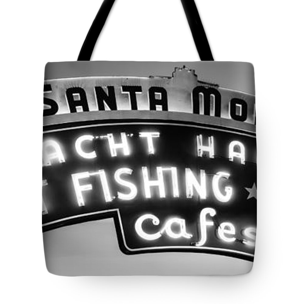 America Tote Bag featuring the photograph Santa Monica Pier Sign Panoramic Black and White Photo by Paul Velgos
