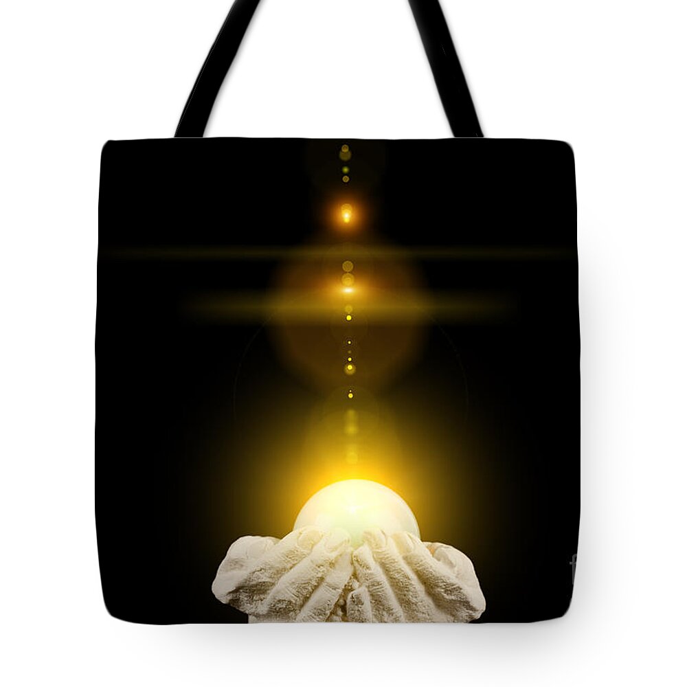 God Tote Bag featuring the photograph Spiritual healing light in cupped hands on black by Simon Bratt
