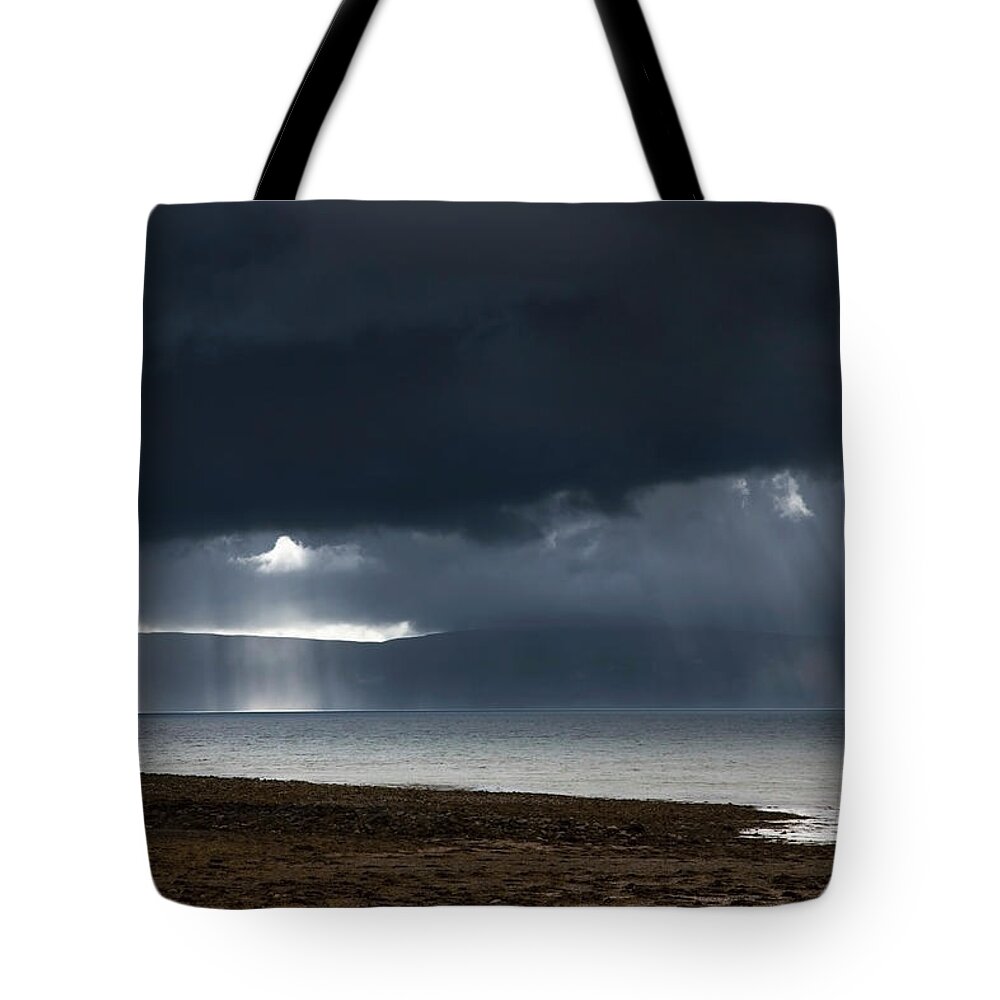 Scotland Tote Bag featuring the photograph Sunbeams Shine Through Dark Storm by John Short / Design Pics