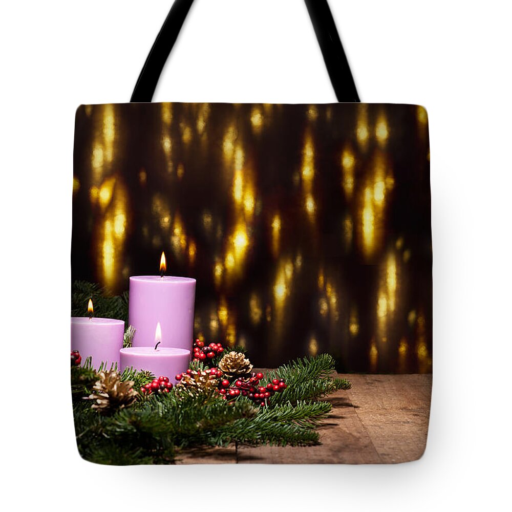 Holly Tote Bag featuring the photograph Three candles in an advent flower arrangement by U Schade