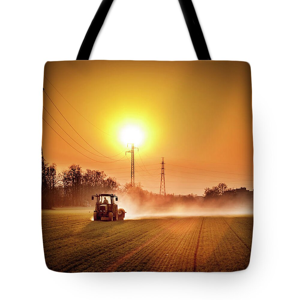 Working Tote Bag featuring the photograph Tractor In A Field At Sunset by Rinocdz