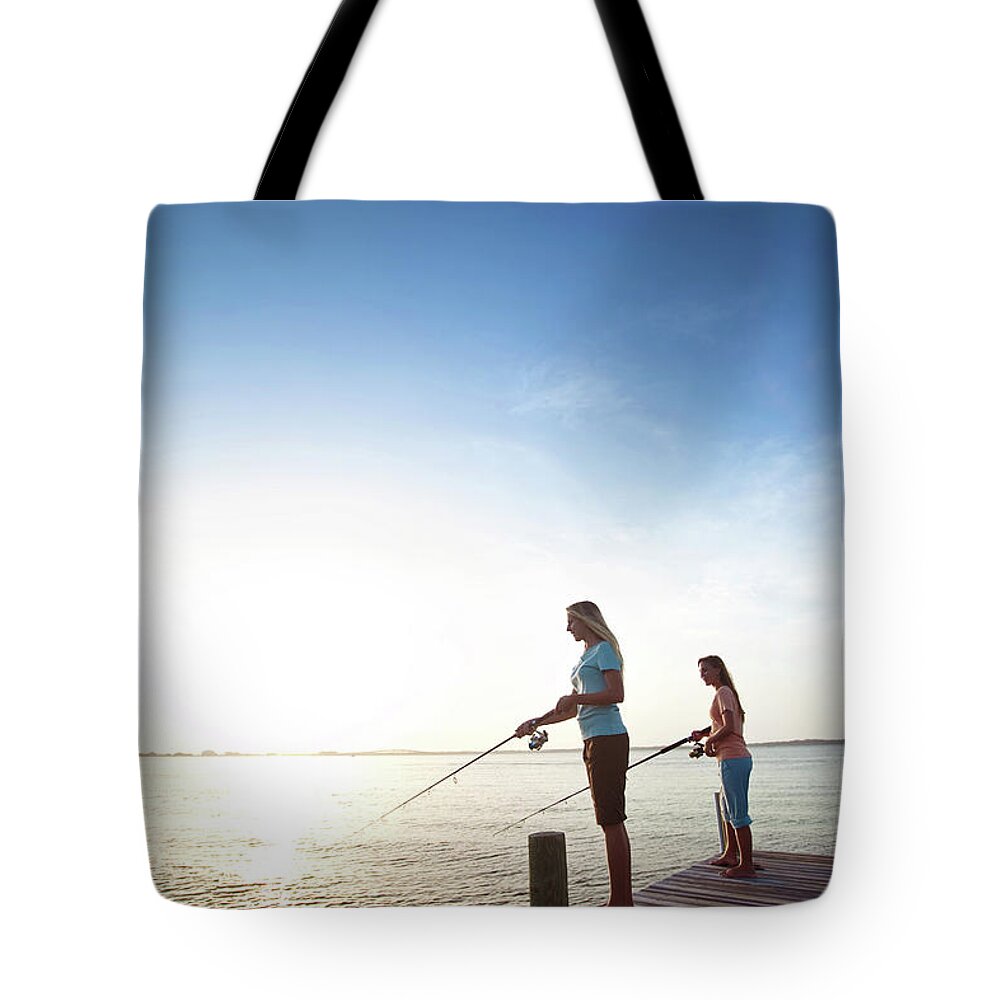 Two Girls Fish Off A Pier On The Santa Tote Bag by Corey Nolen - Fine Art  America