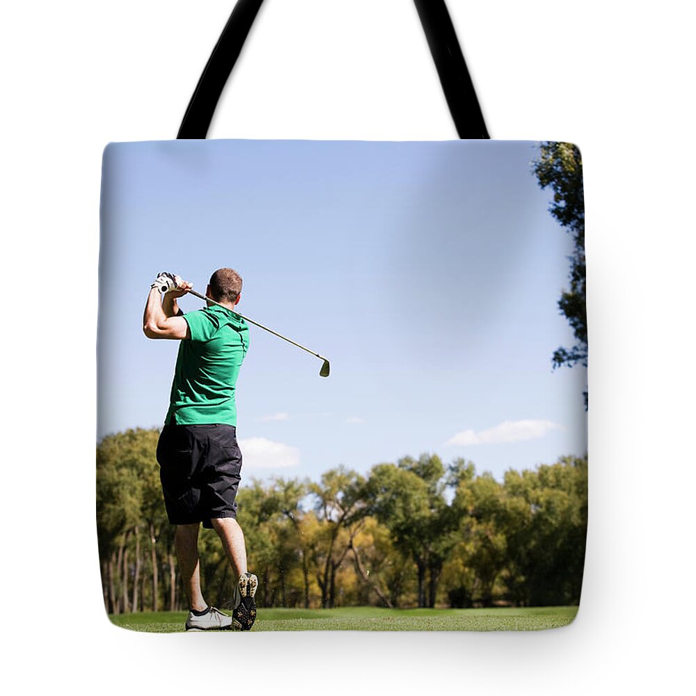 Grass Tote Bag featuring the photograph Usa, Colorado, Rear View Of Man Hitting by Tetra Images - Maisie Paterson