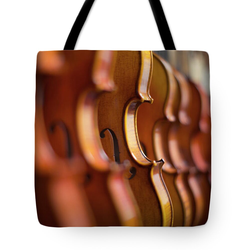 Music Tote Bag featuring the photograph Violins In A Row In A Shop by Eternity In An Instant