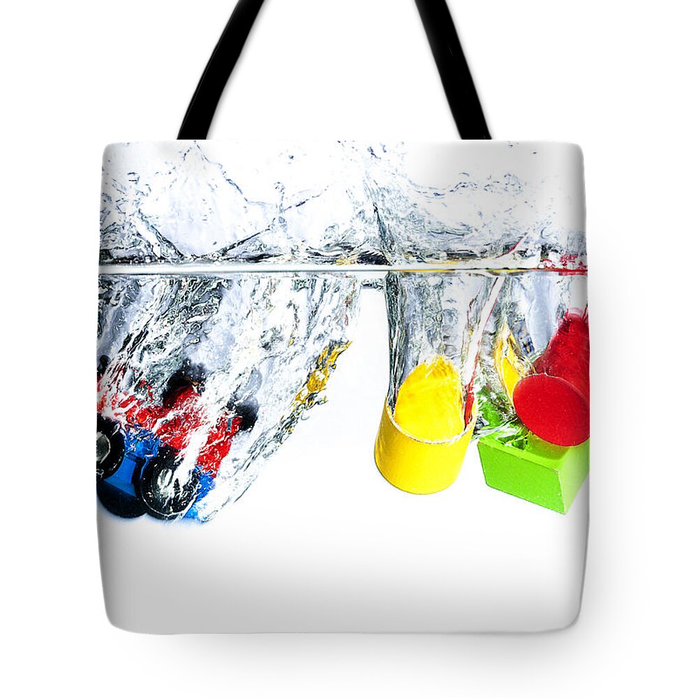 Toys Tote Bag featuring the photograph Wooden toys in water by Mike Santis