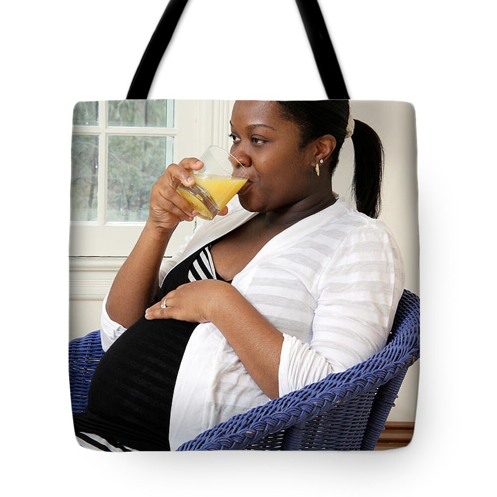 9 Months Tote Bag featuring the photograph Pregnant Woman Drinking Orange Juice #1 by Photo Researchers