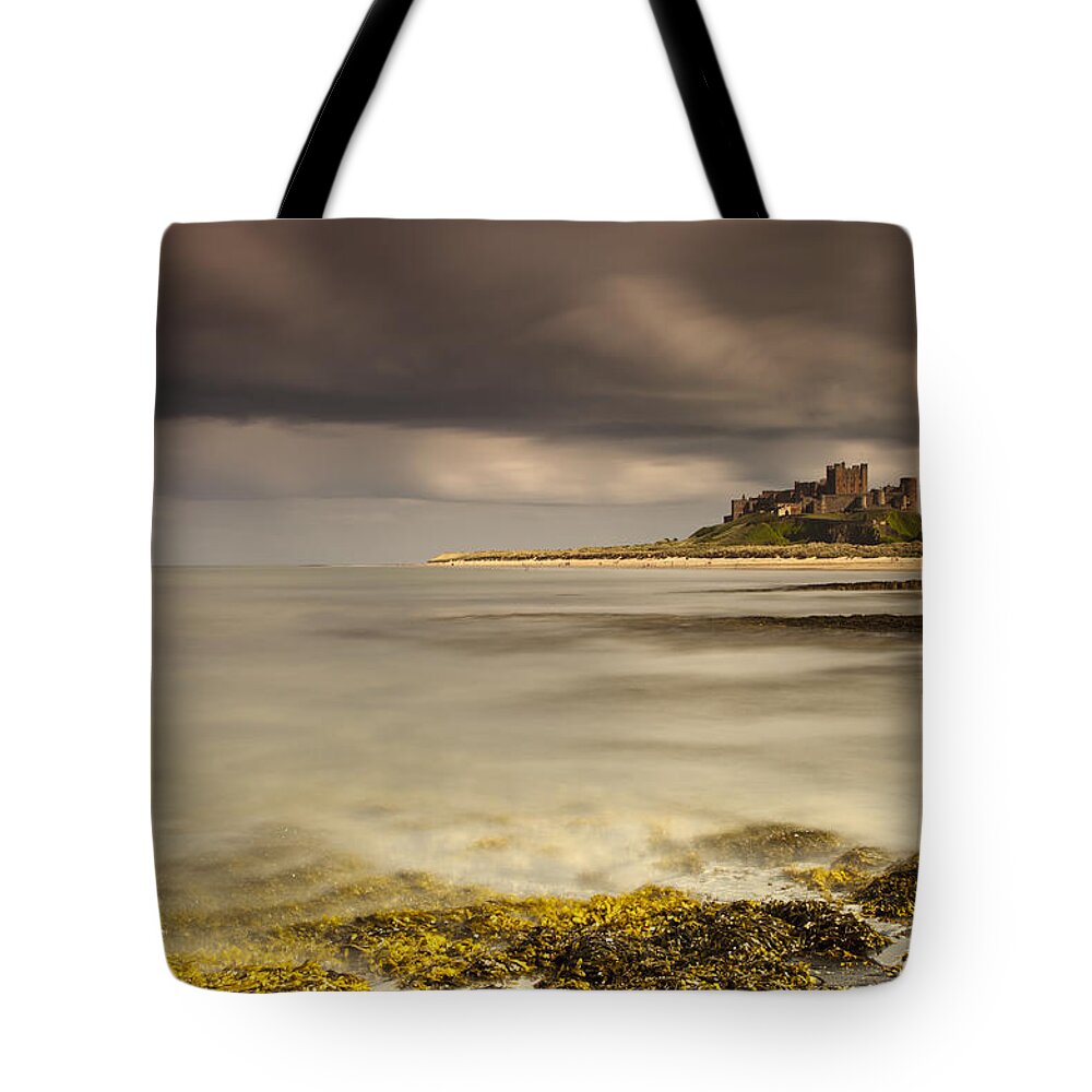 Ocean Tote Bag featuring the photograph Bamburgh Castle Under A Cloudy Sky by John Short