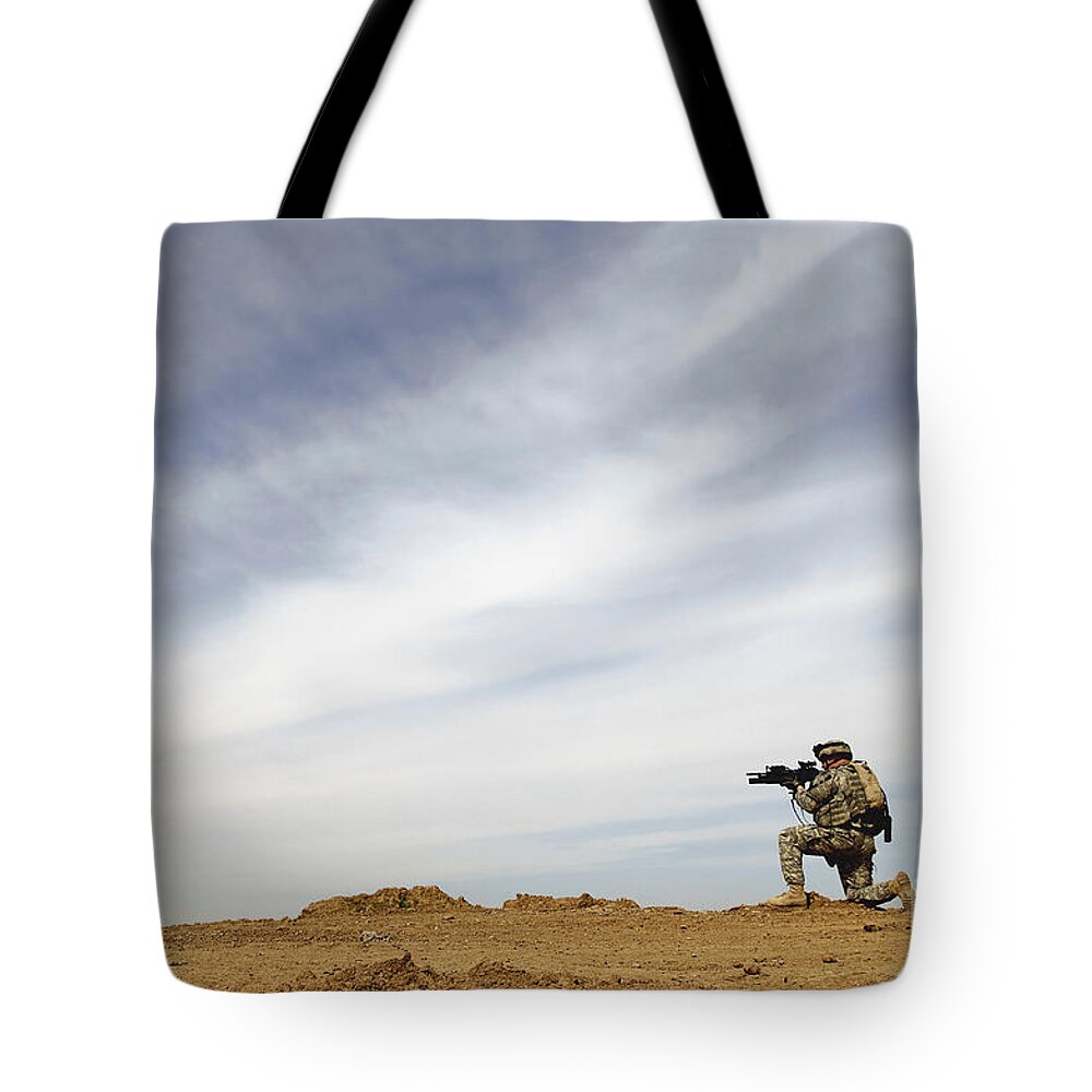 Aiming Tote Bag featuring the photograph U.s. Army Sergeant Provides Security by Stocktrek Images