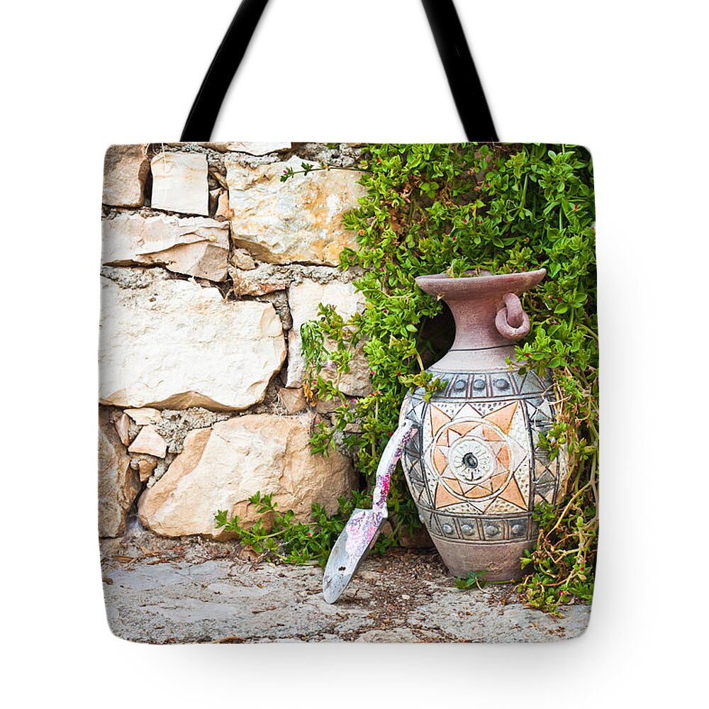 Background Tote Bag featuring the photograph Vase and trowel by Tom Gowanlock