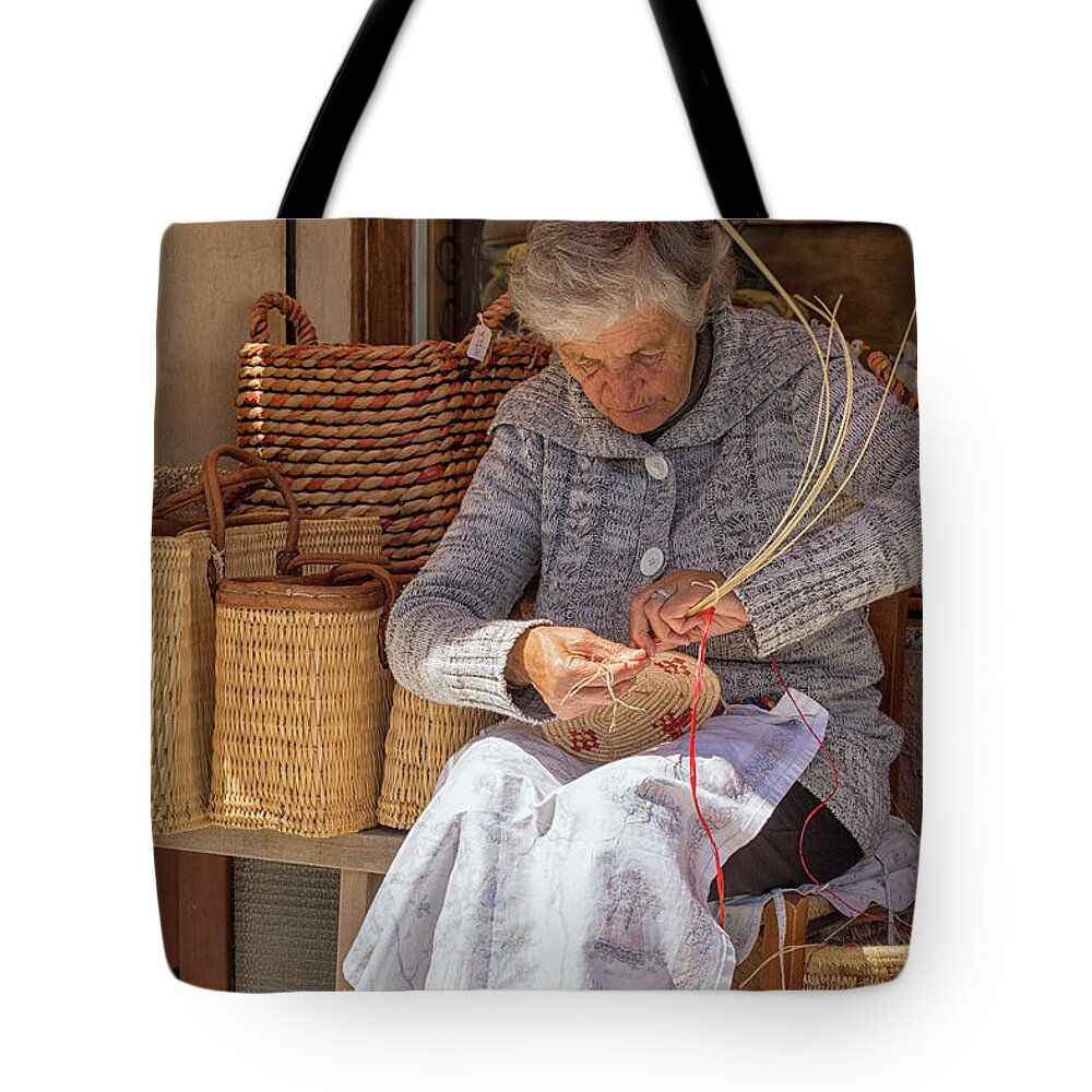 Adult Tote Bag featuring the photograph A woman weaving a basket in Castelsardo by Patricia Hofmeester