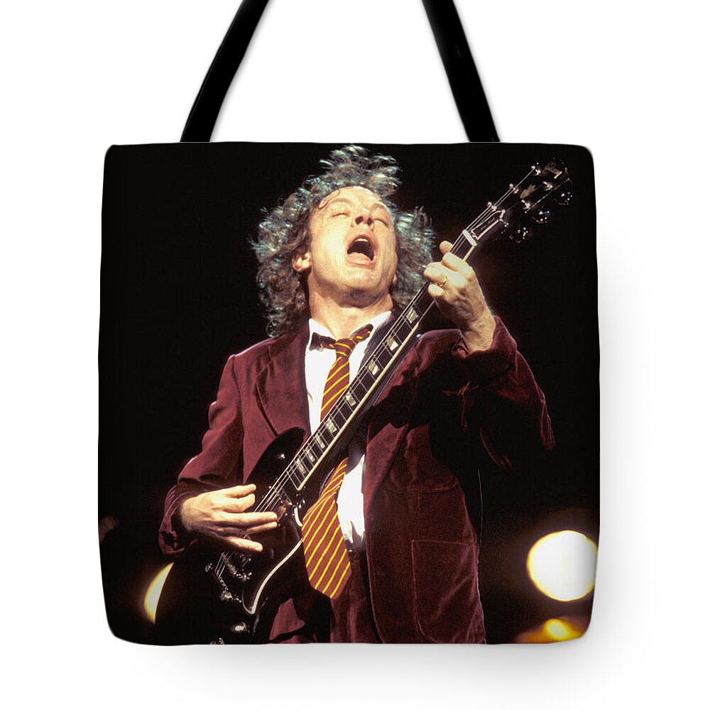 Ac/dc Guitarist Angus Young Is Shown Performing On Stage During A Live Concert Appearance Tote Bag featuring the photograph Ac Dc - Angus Young #1 by Concert Photos