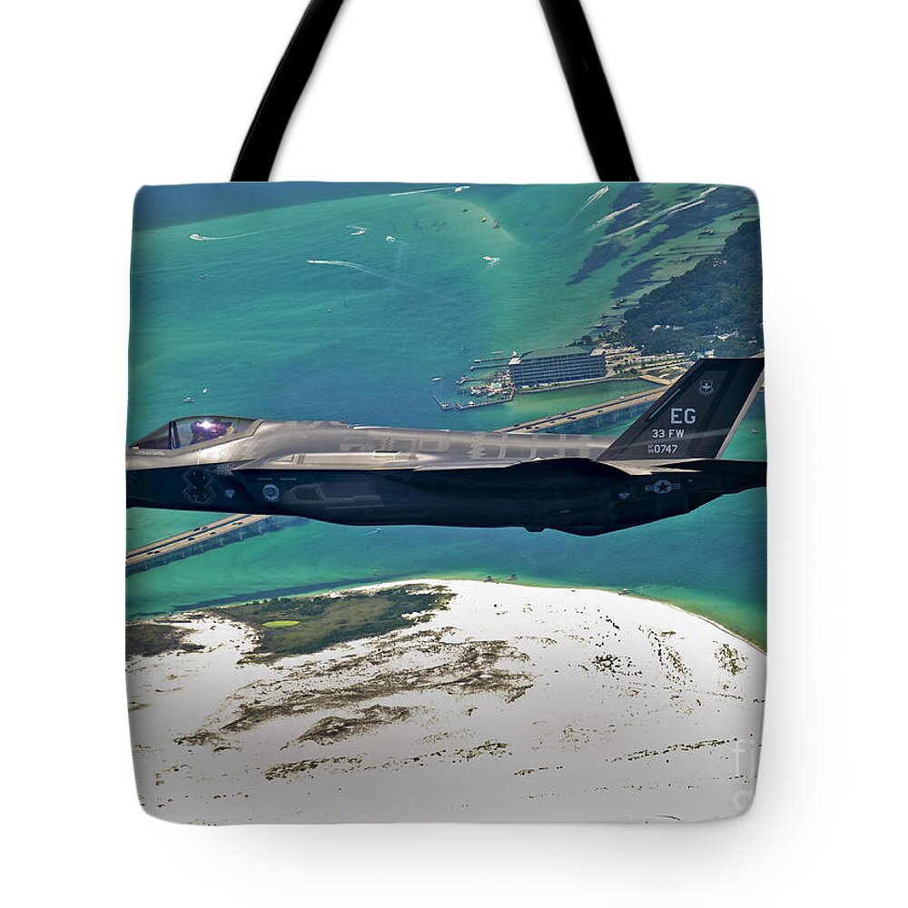 Stealth Tote Bag featuring the photograph An F-35 Lightning II Flies Over Destin by Stocktrek Images