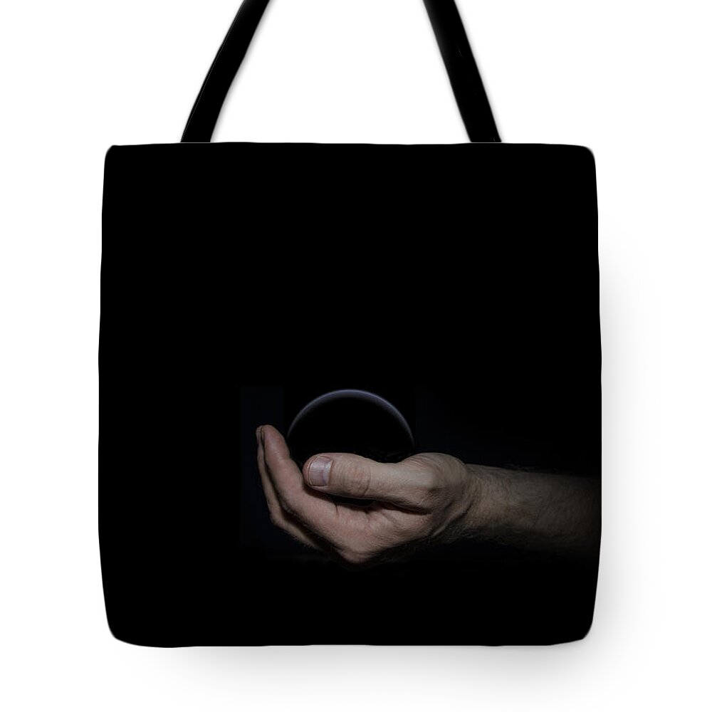 Black Tote Bag featuring the digital art Black Sphere in Hand by Pelo Blanco Photo