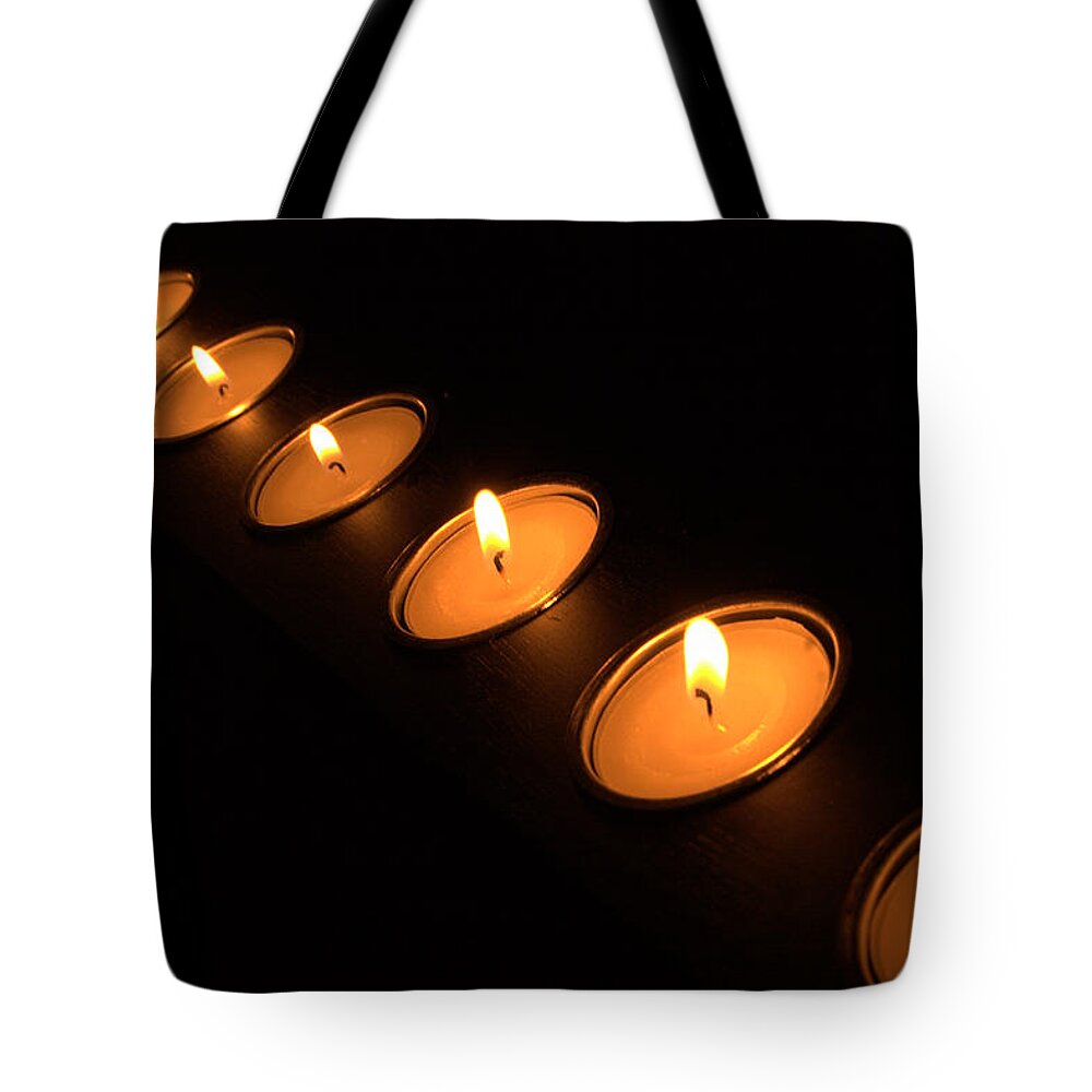 Candle Tote Bag featuring the photograph Candles in a row by Alexander Fedin