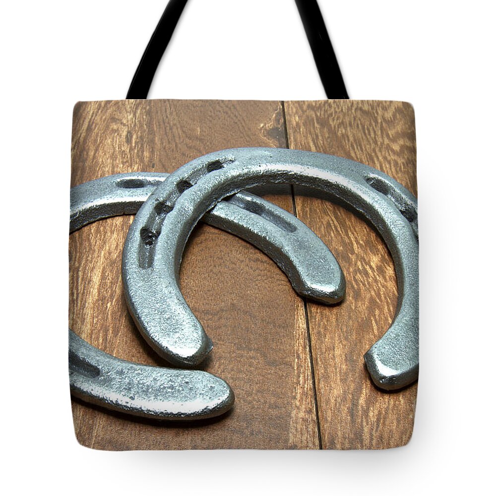 Cast Iron Tote Bag featuring the photograph Cast Iron Horseshoes on Barn Wood by Karen Foley