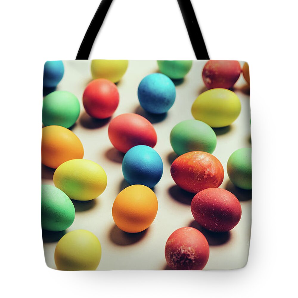 Egg Tote Bag featuring the photograph Couple of colorful eggs laying on a creamy background. by Michal Bednarek