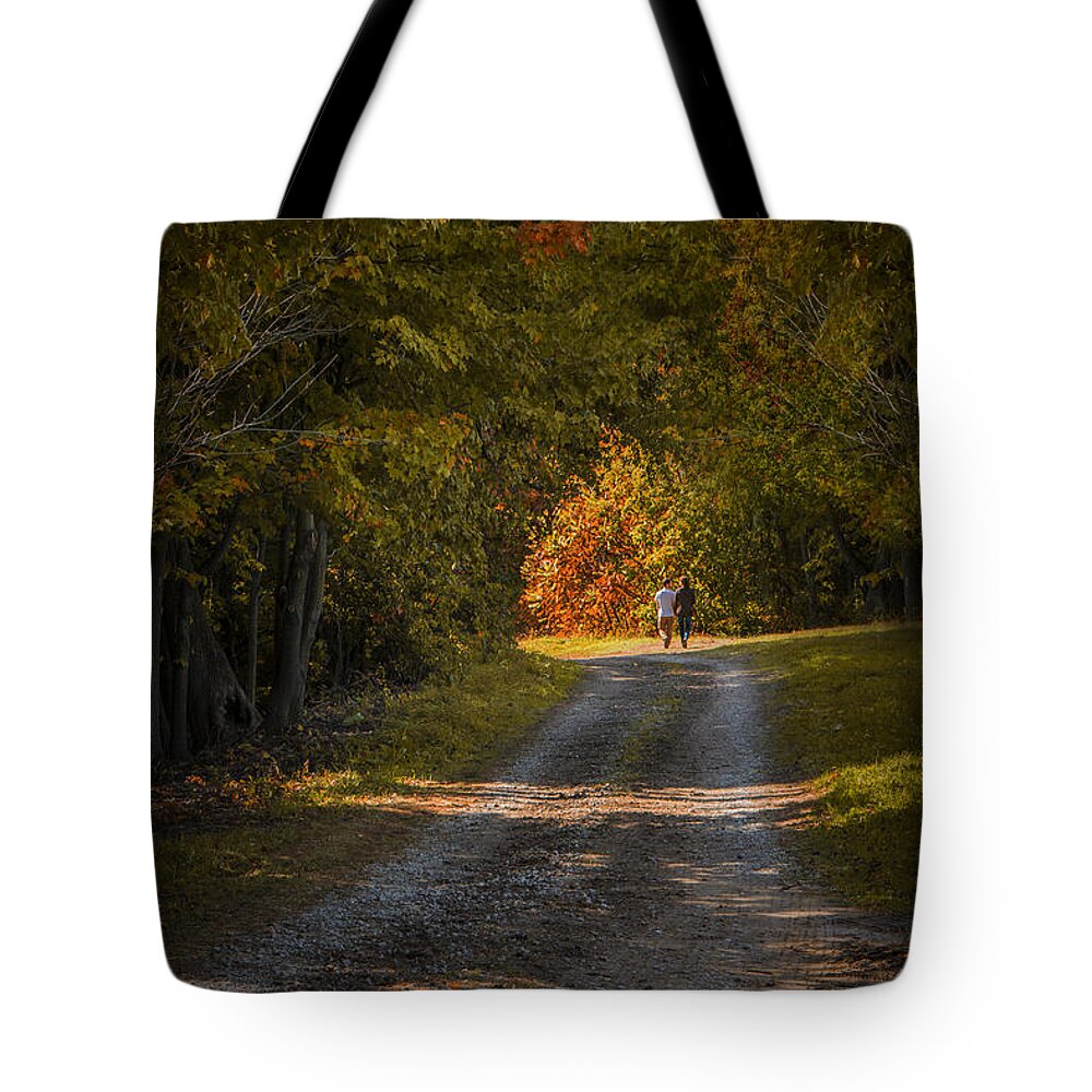 Art Tote Bag featuring the photograph Couple walking on a Dirt Road through a Tree Canopy during Autumn by Randall Nyhof