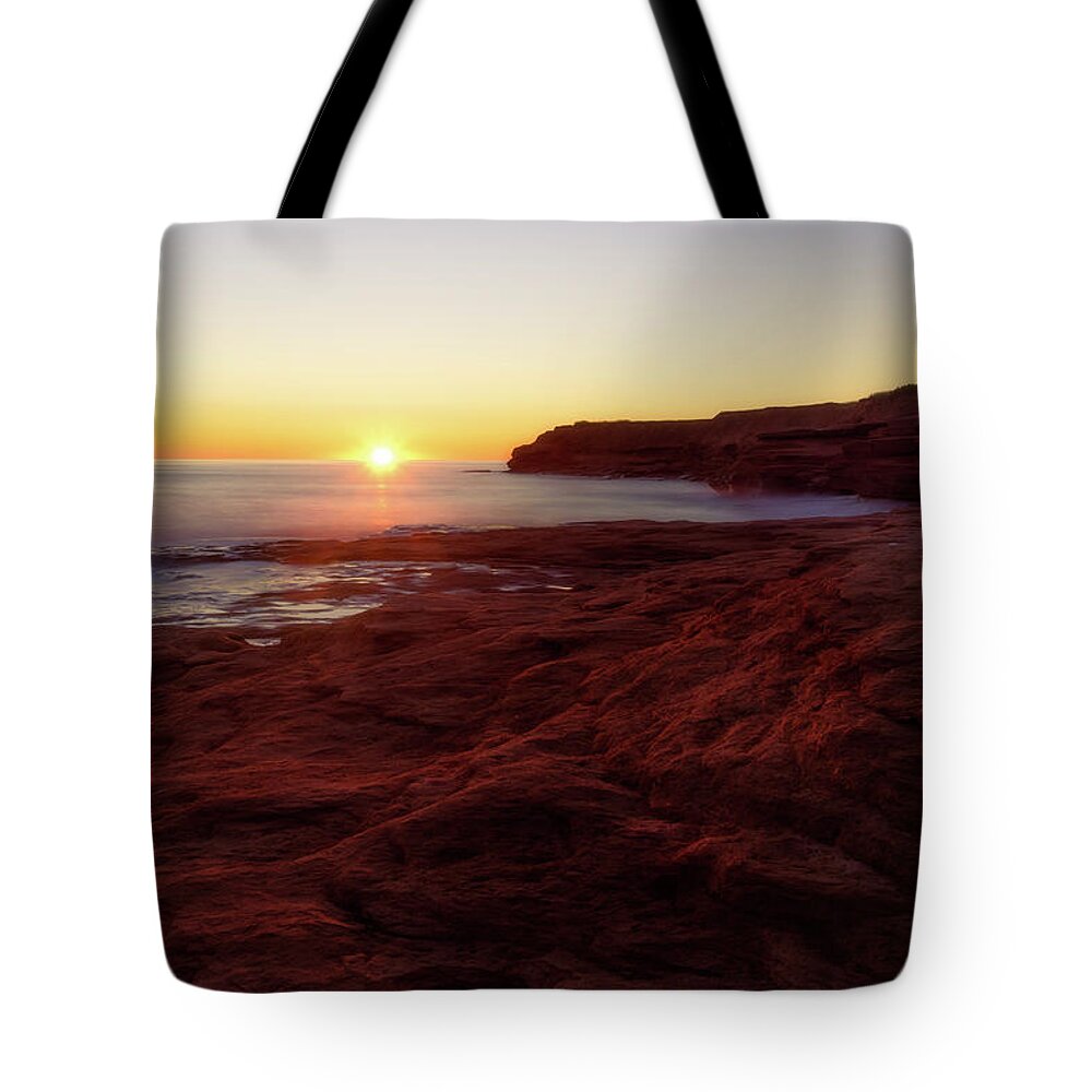 Bluffs By The Ocean Tote Bag featuring the photograph First light on Red Sandstone beach by Chris Bordeleau