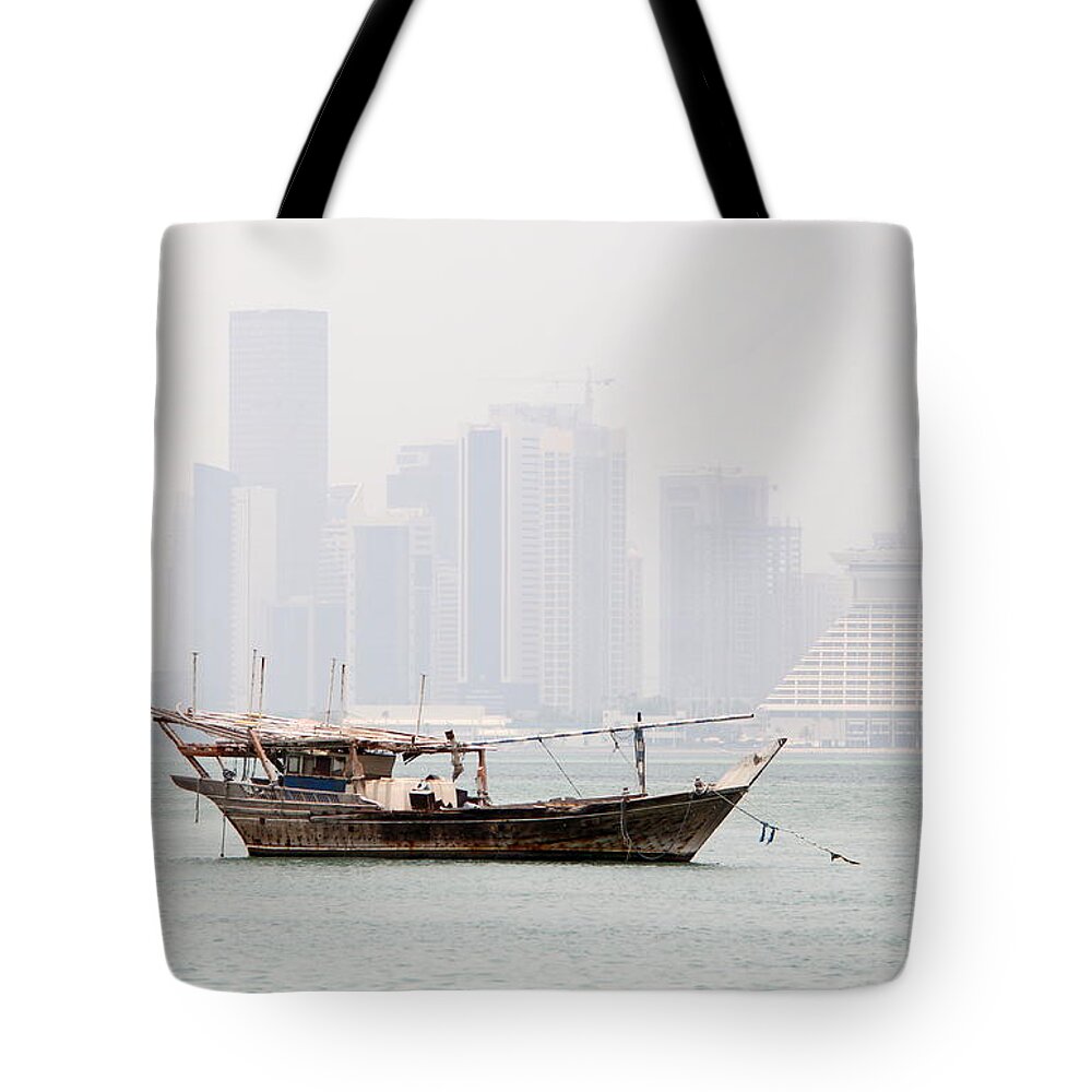 Dhow Tote Bag featuring the photograph Fishing dhow and misty towers by Paul Cowan