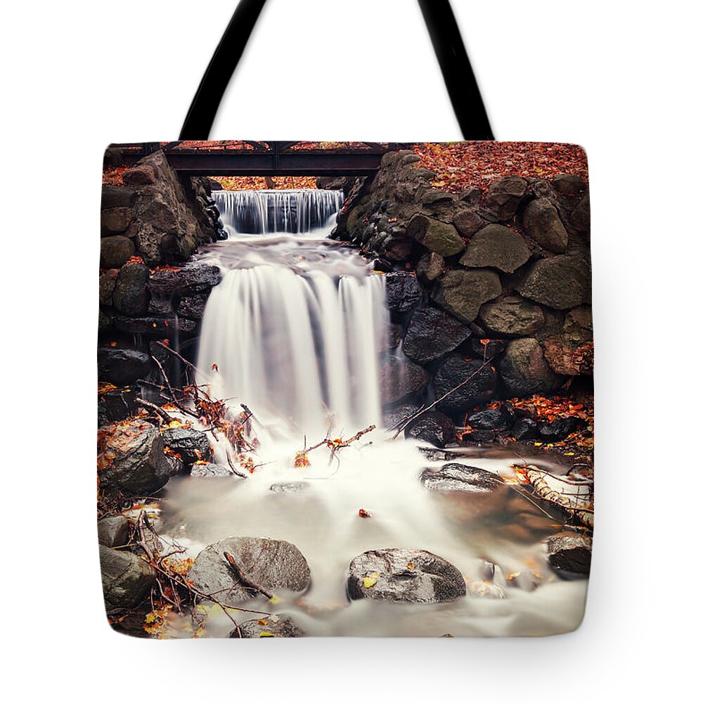 Autumn Tote Bag featuring the photograph Forest waterfall by foot bridge by Sophie McAulay