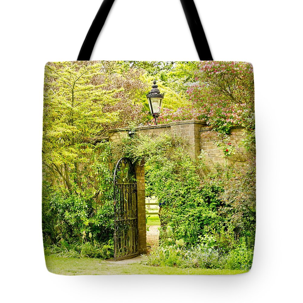 Garden Wall Tote Bag featuring the photograph Garden Wall With Iron Gate And Lantern. by Elena Perelman