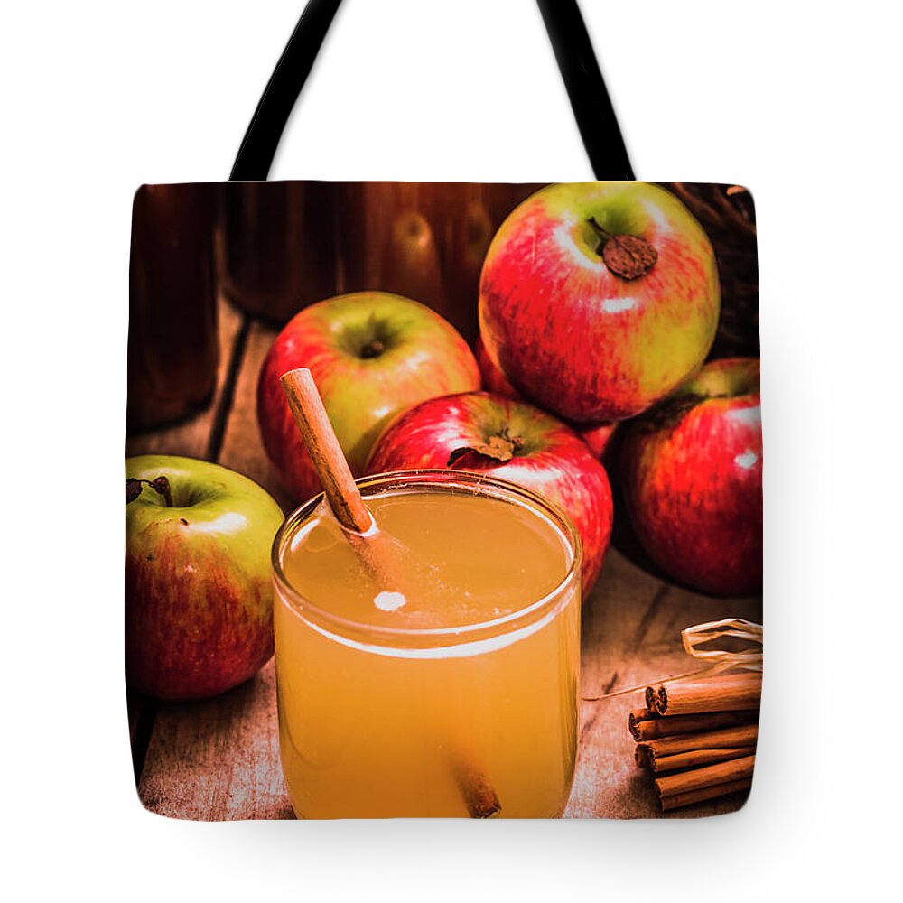 Apple Tote Bag featuring the photograph Glass of fresh apple cider by Jorgo Photography