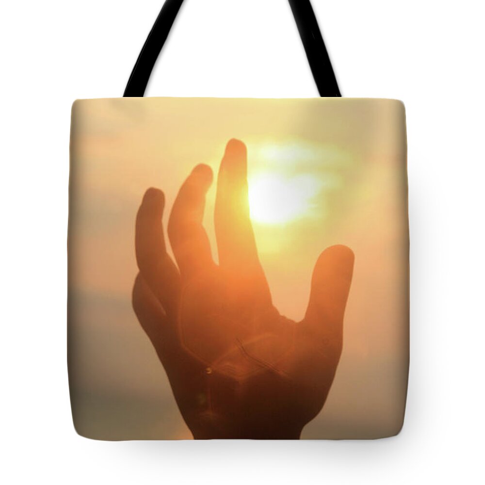 Hand Tote Bag featuring the photograph Hand reaching fore the sun by Emanuel Tanjala