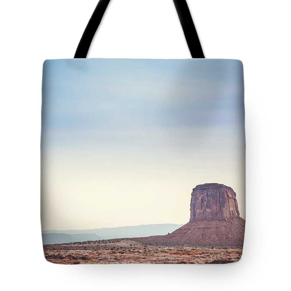 Sunset Tote Bag featuring the photograph Hazy sunset over Mitchell Butte, Monument Valley by Mati Krimerman