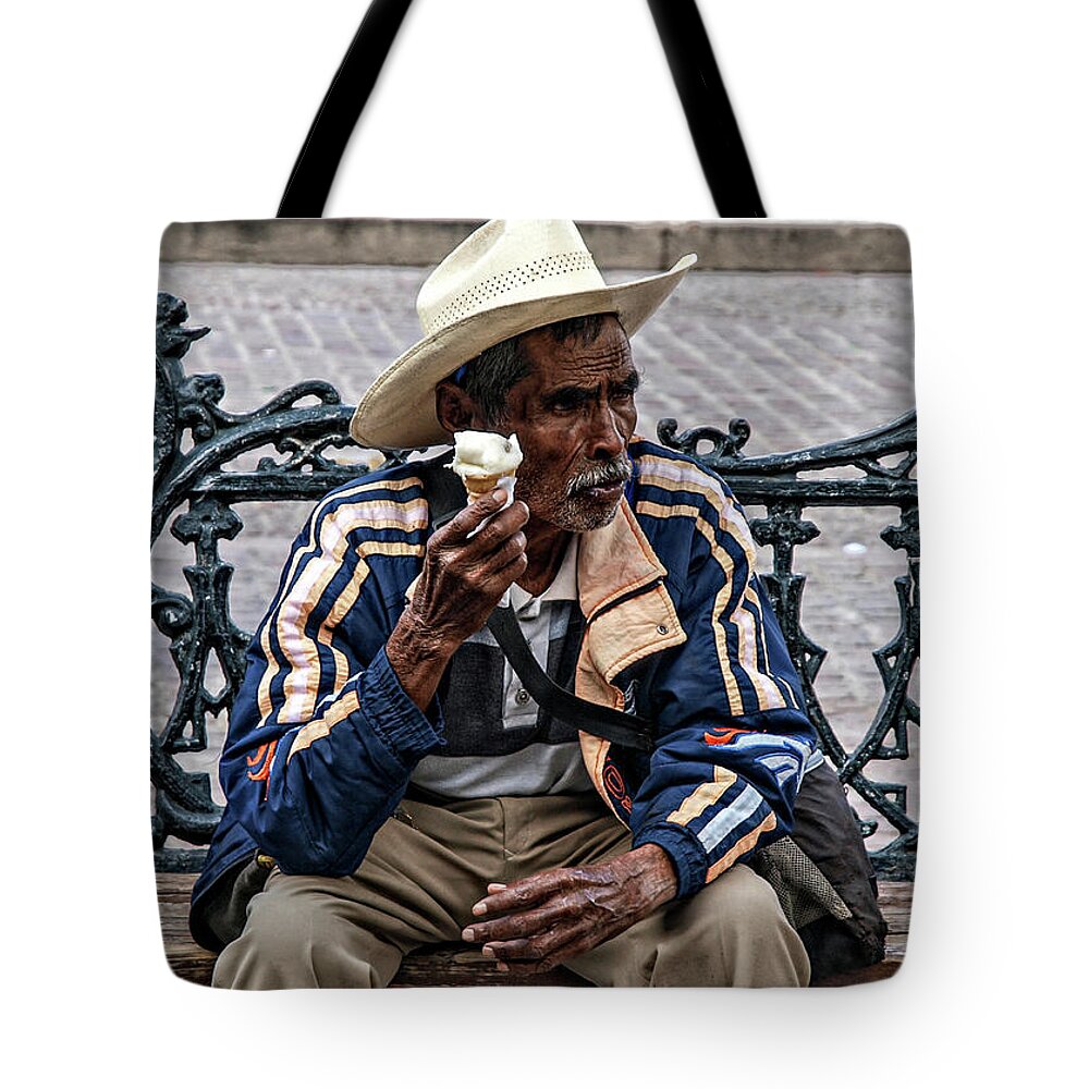 Rebecca Dru Photography Tote Bag featuring the photograph Man on bench eating Nieve by Rebecca Dru