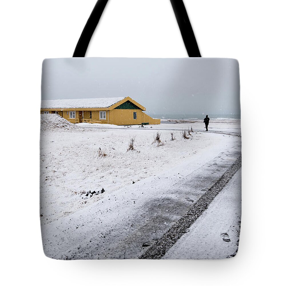 Iceland Tote Bag featuring the photograph Man walking in snow Iceland by Michalakis Ppalis