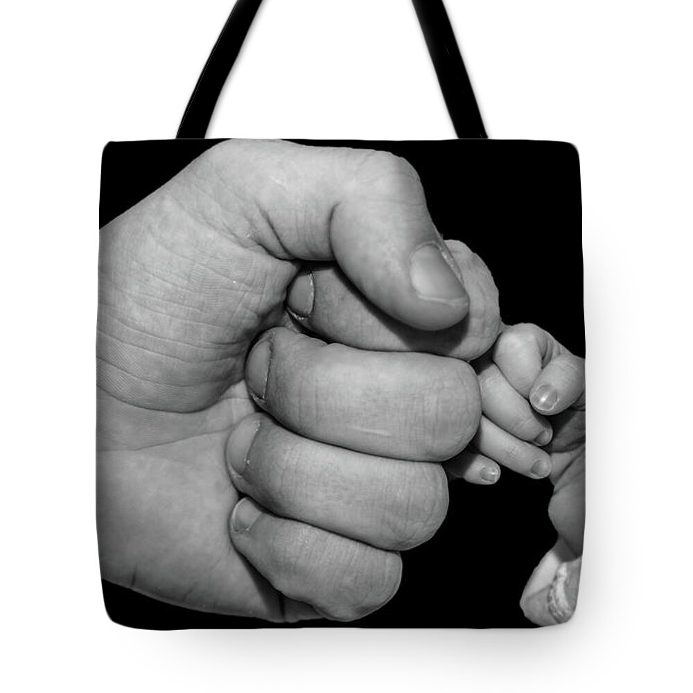 New Born Tote Bag featuring the photograph New born fist bump by Joe Holley
