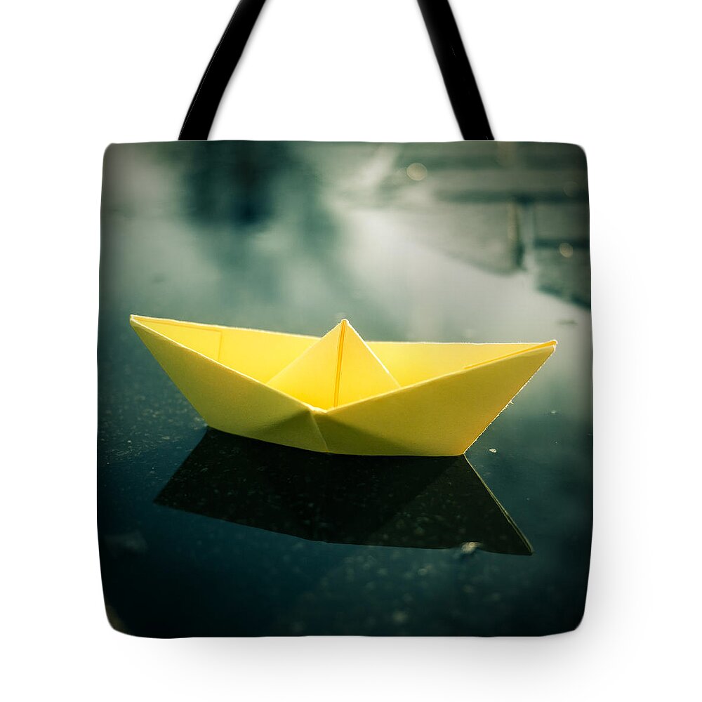 Paperboat Puddle Water Origami Tote Bag featuring the photograph Paper Boat Puddle by Janine Pauke