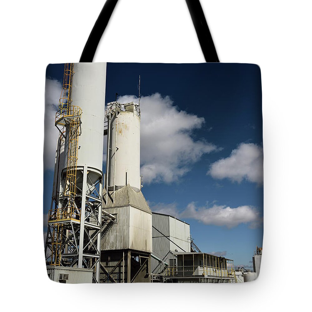 Cement Tote Bag featuring the photograph Portland cement plant with ground clinker silos with blue sky by Reimar Gaertner