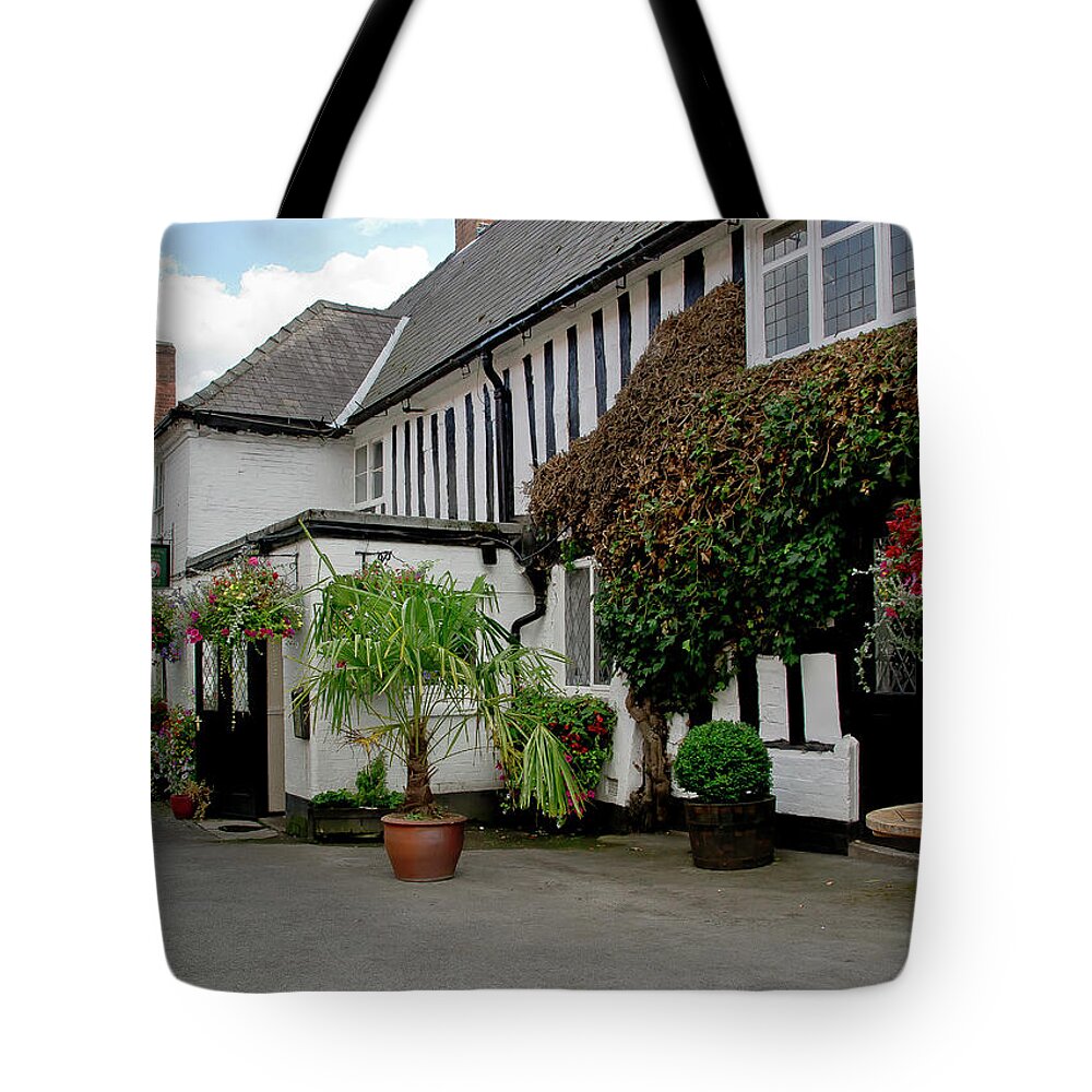 White House Tote Bag featuring the photograph Quiet street with flowers on walls. by Elena Perelman