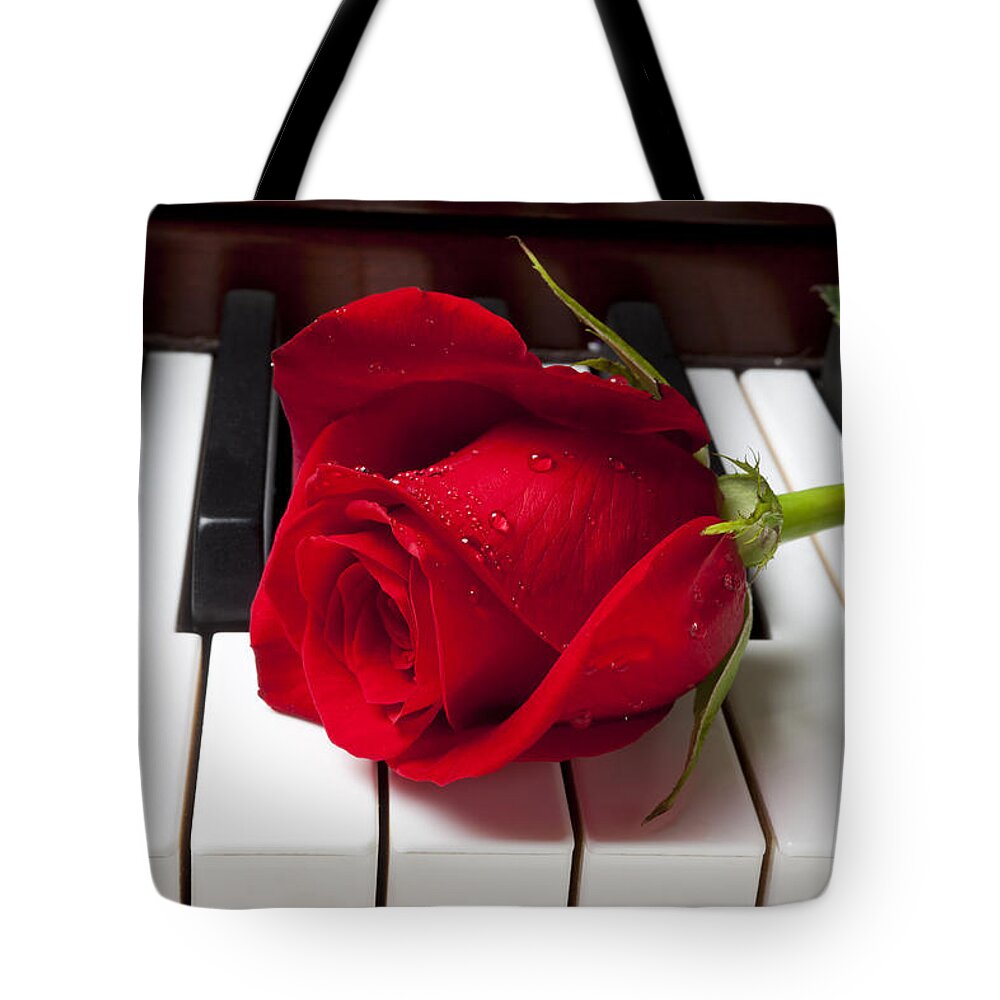 Red Rose Roses Tote Bag featuring the photograph Red rose on piano keys by Garry Gay