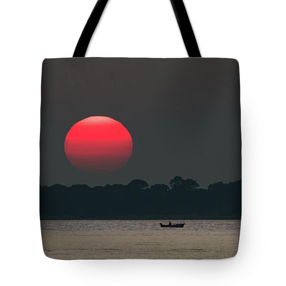 Sun Tote Bag featuring the photograph Red Sun at Sunset at Sea with Fishing Boat by Andreas Berthold