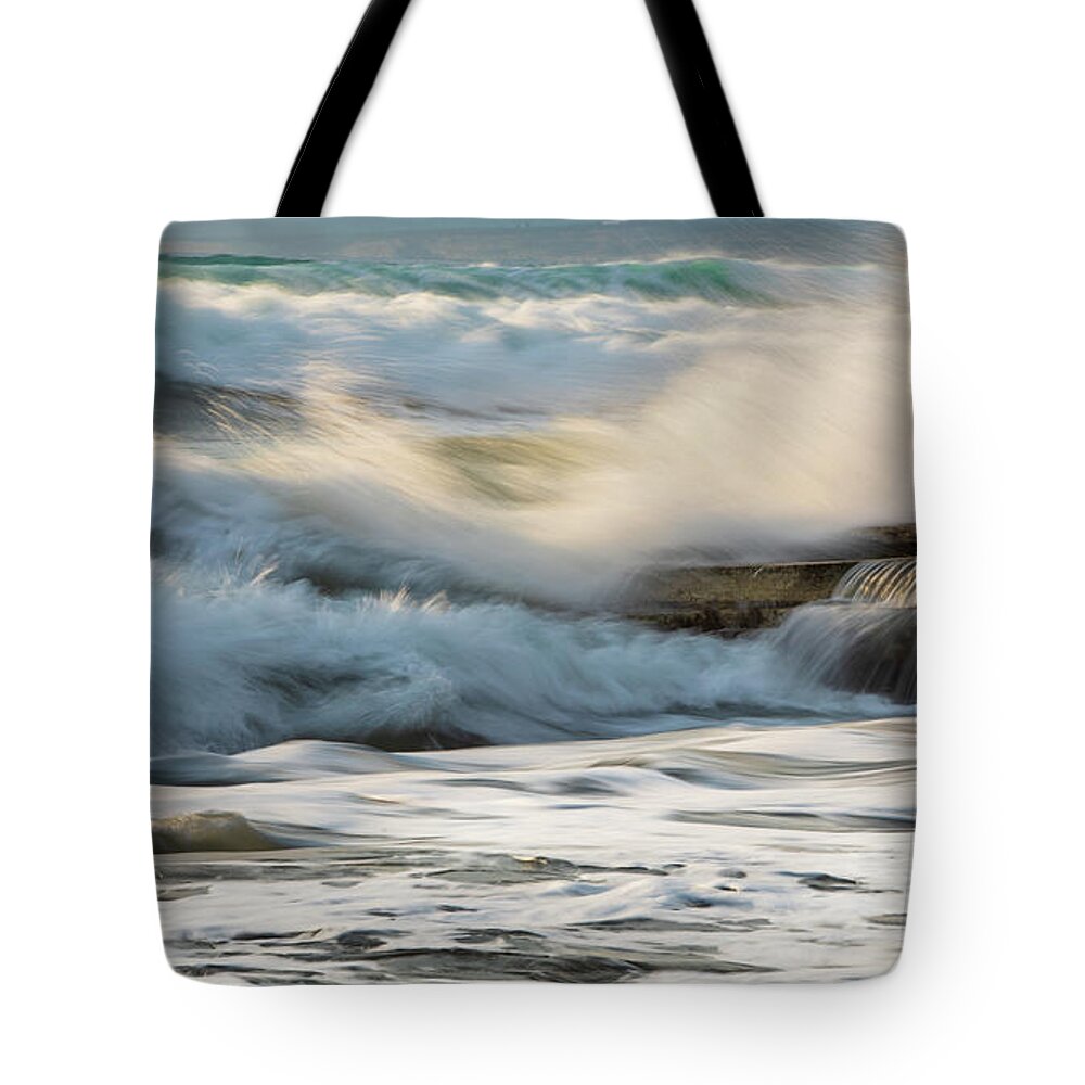 Sea Waves Tote Bag featuring the photograph Rocky seashore, wavy ocean and wind waves crashing on the rocks by Michalakis Ppalis