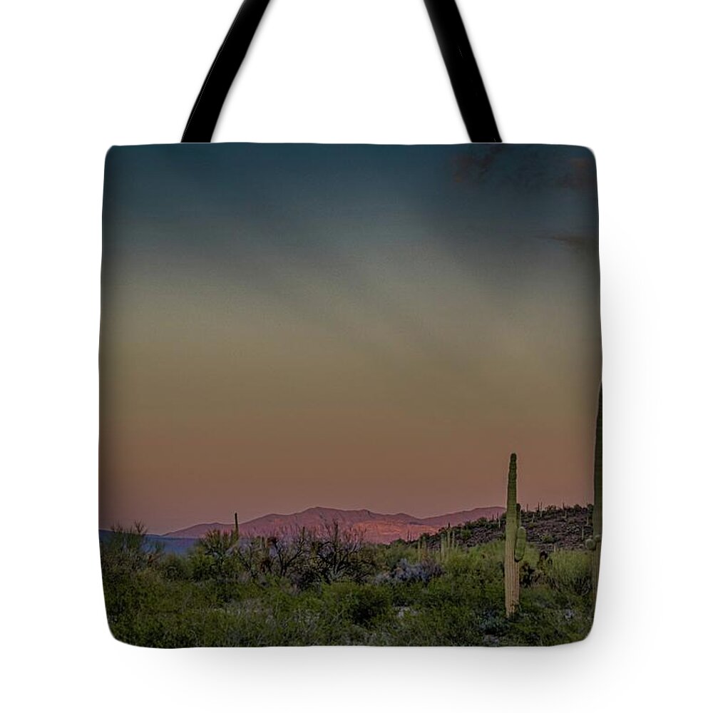 Anticrepuscular Rays Tote Bag featuring the photograph Saguaros salute rays rising by Gaelyn Olmsted