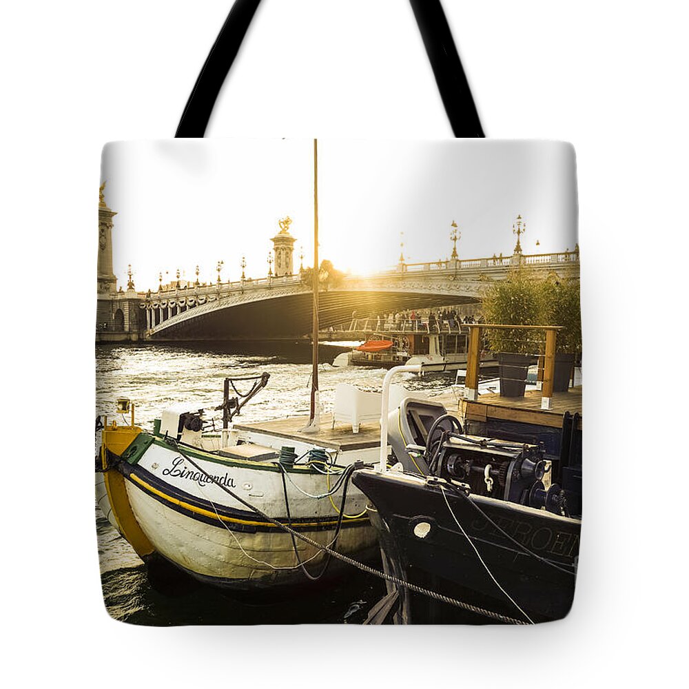 Seine Tote Bag featuring the photograph Seine river with barges and boats, Pont de Alexandre bridge behind, Paris France. by Perry Van Munster